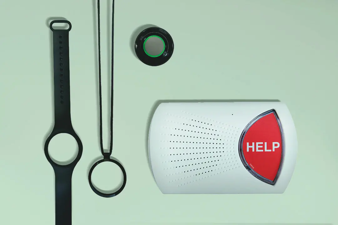 Medical alert base station, wristband, and necklace on green background