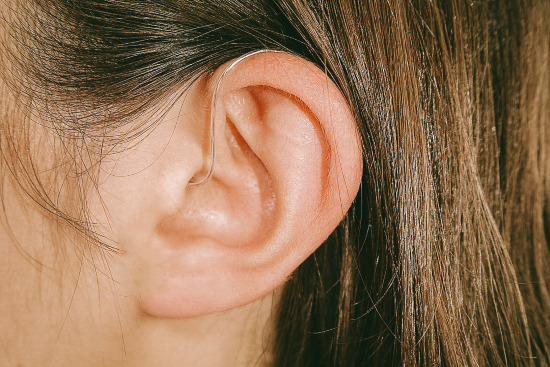 Jabra Enhance Select 100 hearing aid in white woman’s ear
