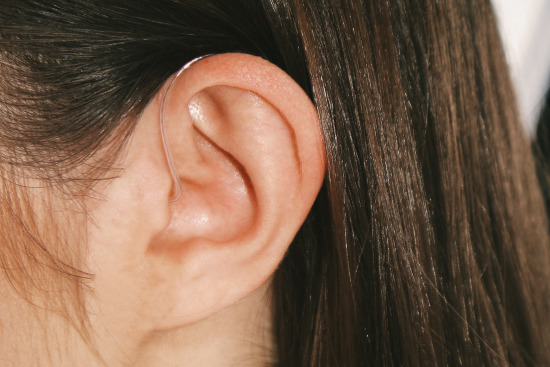 Lexie hearing aid in white woman’s ear