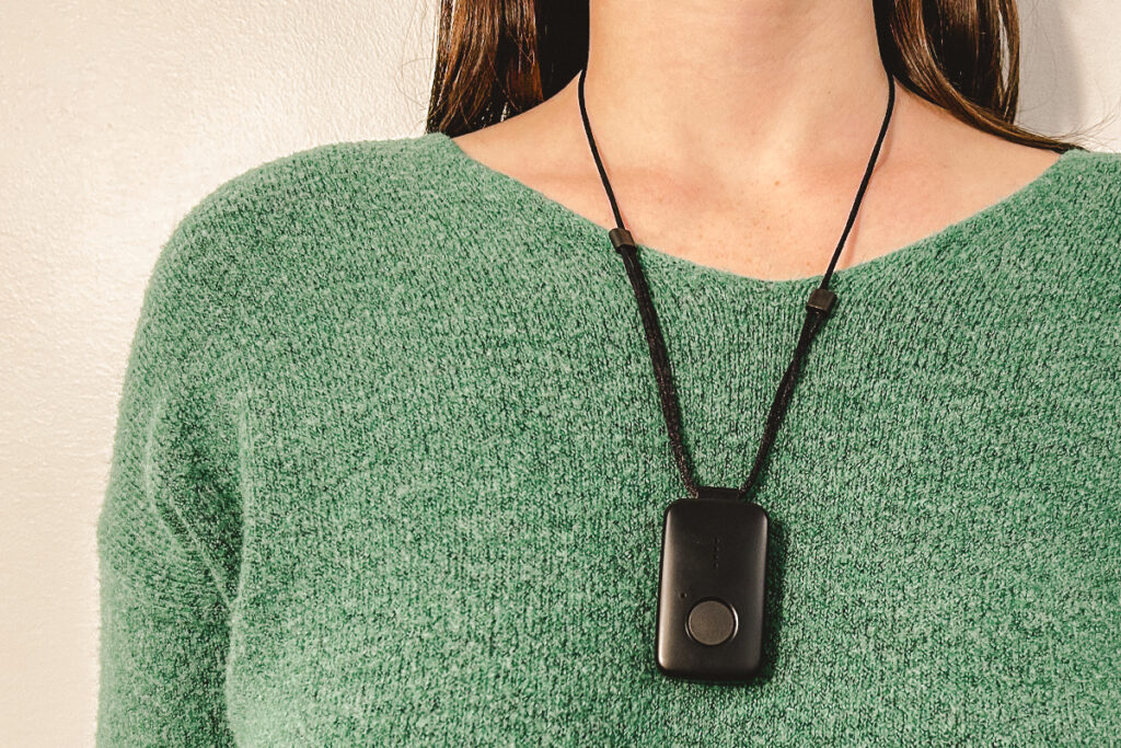 Person in a green sweater wearing the black MGMini as a necklace.
