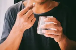 Person taking a pill with water