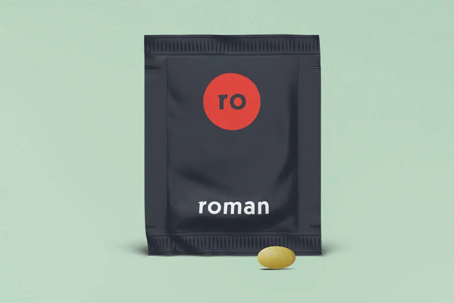 One yellow pill in front of a black Roman sachet against a green background