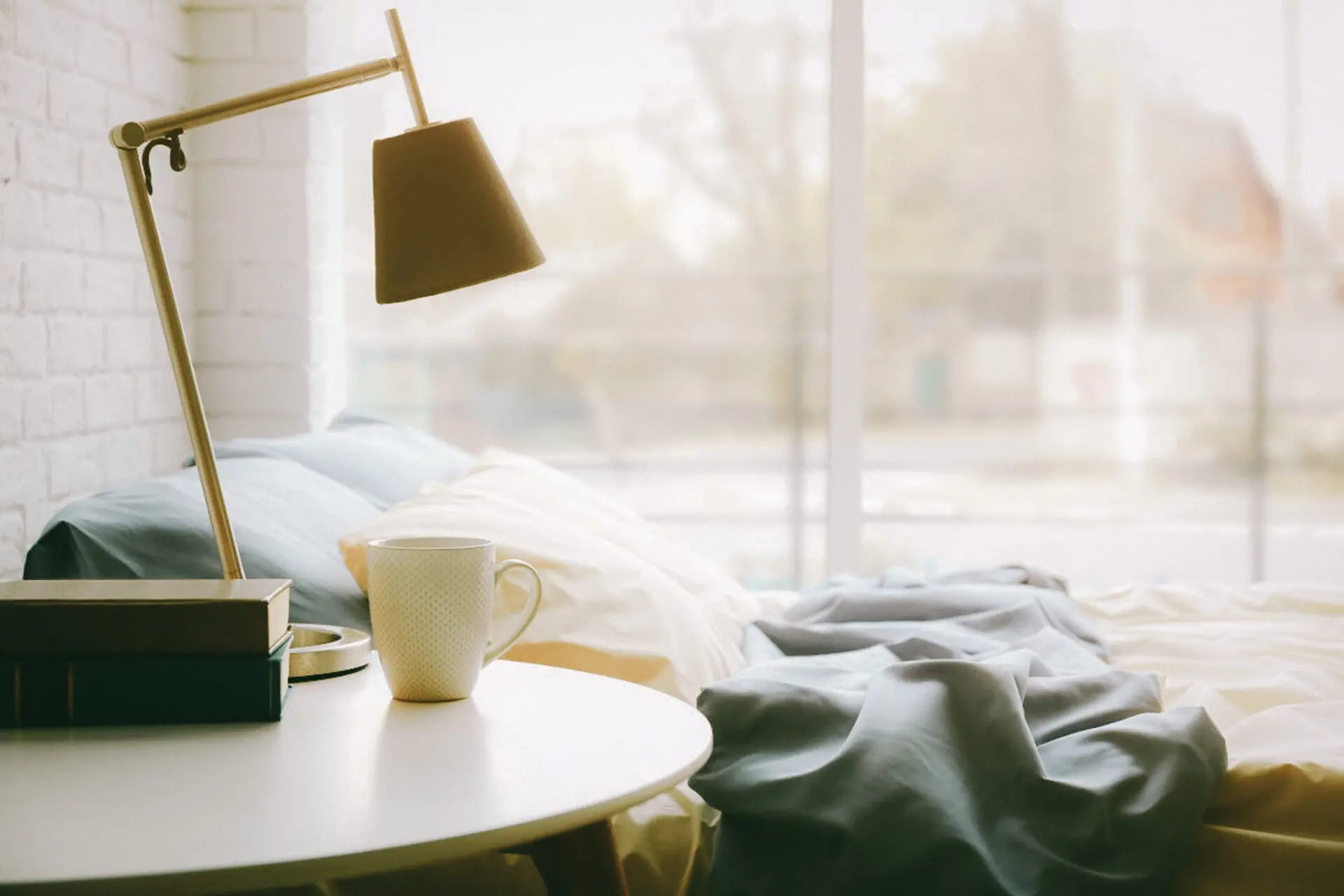 lamp sitting on nightstand next to bed